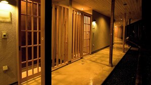 A corridor with wooden sliding doors and a concrete floor. - Mutsumian (Kawazu)
