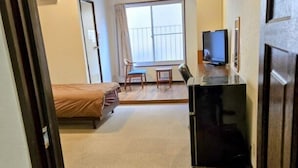 A room with a bed, a desk with a computer, a chair, and a window with curtains. - Business Hotel Nishiwaki (Nishiwaki)