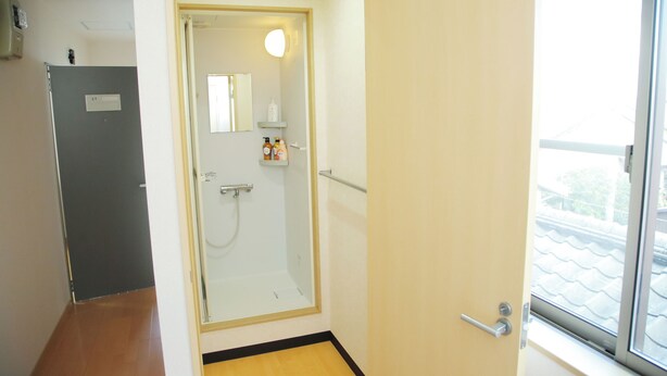 A bathroom with a glass shower enclosure, a mirror, and a window. - I Eco III (Niigata)