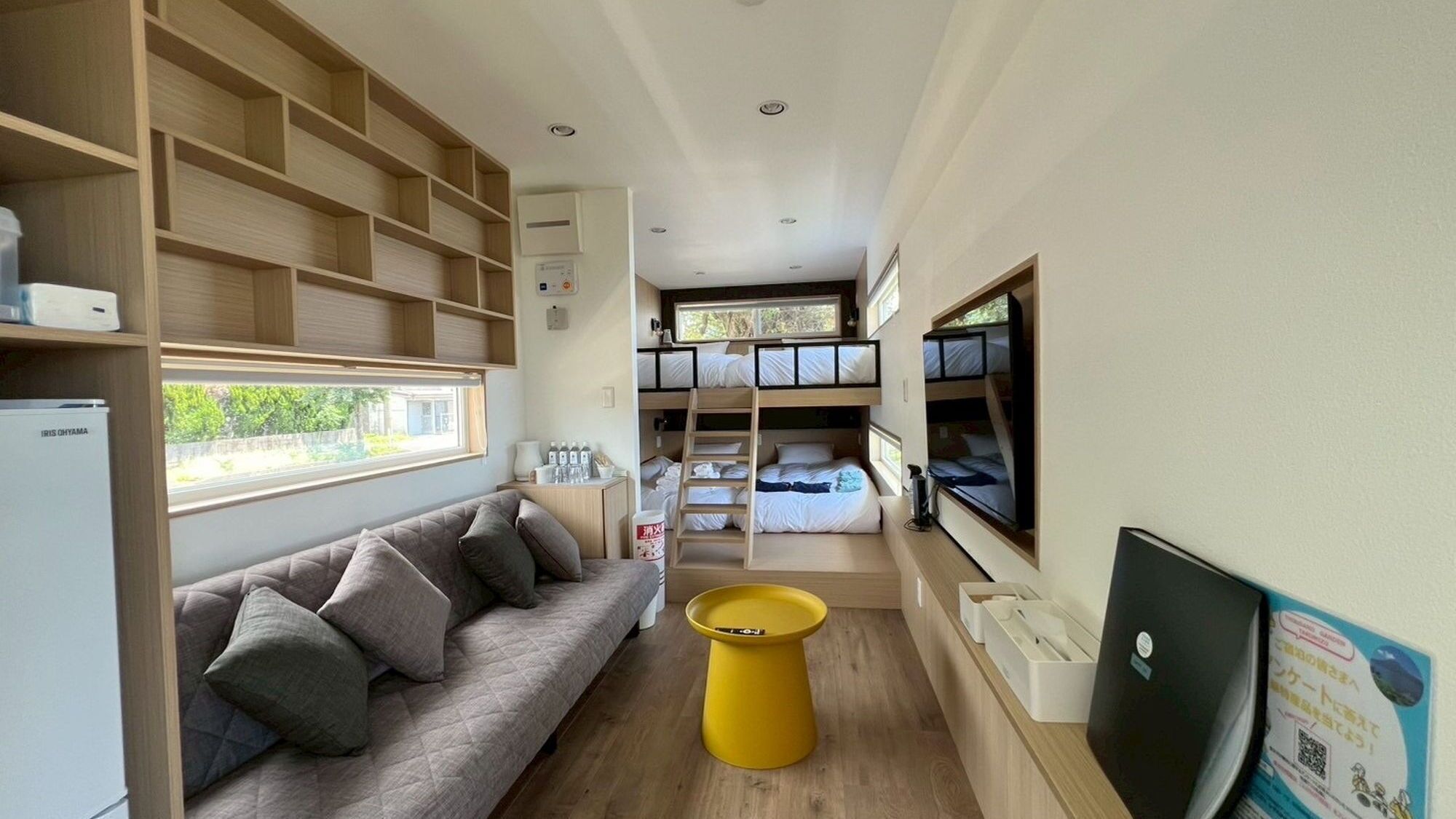 Habitación compacta y moderna con literas, un sofá y una mesita.
