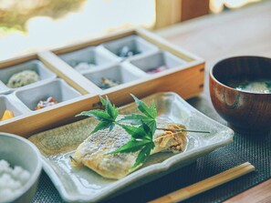 Un repas composé d’un plat de poisson, d’une soupe et d’un plateau compartimenté contenant différents aliments.
