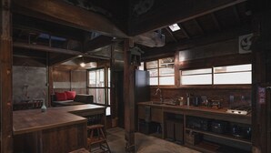 Eine rustikale Küche mit Holzbalken, einem großen Fenster und einer Spüle.