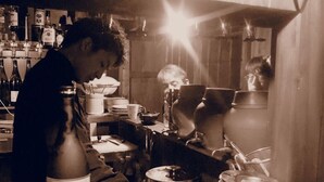 Una cucina con mobili in legno, un fornello e diversi utensili da cucina.