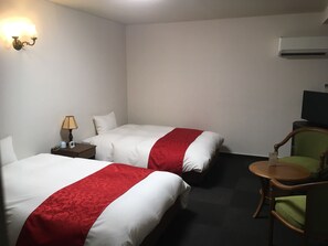 A hotel room with two beds, a desk with a lamp, a chair, and a television. - Hotel Dogo Yunomachi (Matsuyama)