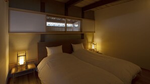 Een slaapkamer met een stapelbed, nachtlampjes en uitzicht door een raam.