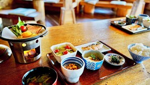 Una tavola imbandita con diversi piatti, tra cui un hot pot, ciotole di riso e piatti di cibo.
