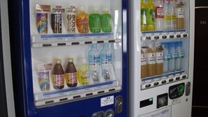 Zwei Getränkeautomaten mit der Aufschrift 'SUNTORY' und 'KIRIN' und einer Auswahl verschiedener Getränke.