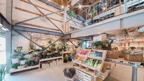 A multi-level indoor market with various stalls selling flowers, plants, and other goods. - Yoshida Mura Inn (Shimotsuke)
