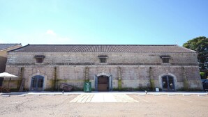 A historic building with a tiled roof and arched doorways. - Yoshida Mura Inn (Shimotsuke)