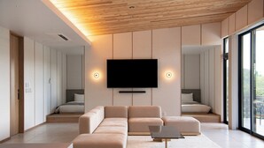A modern living room with a large flat-screen TV mounted on the wall, a sectional sofa, and a coffee table. - Soothe Forest (Awaji)