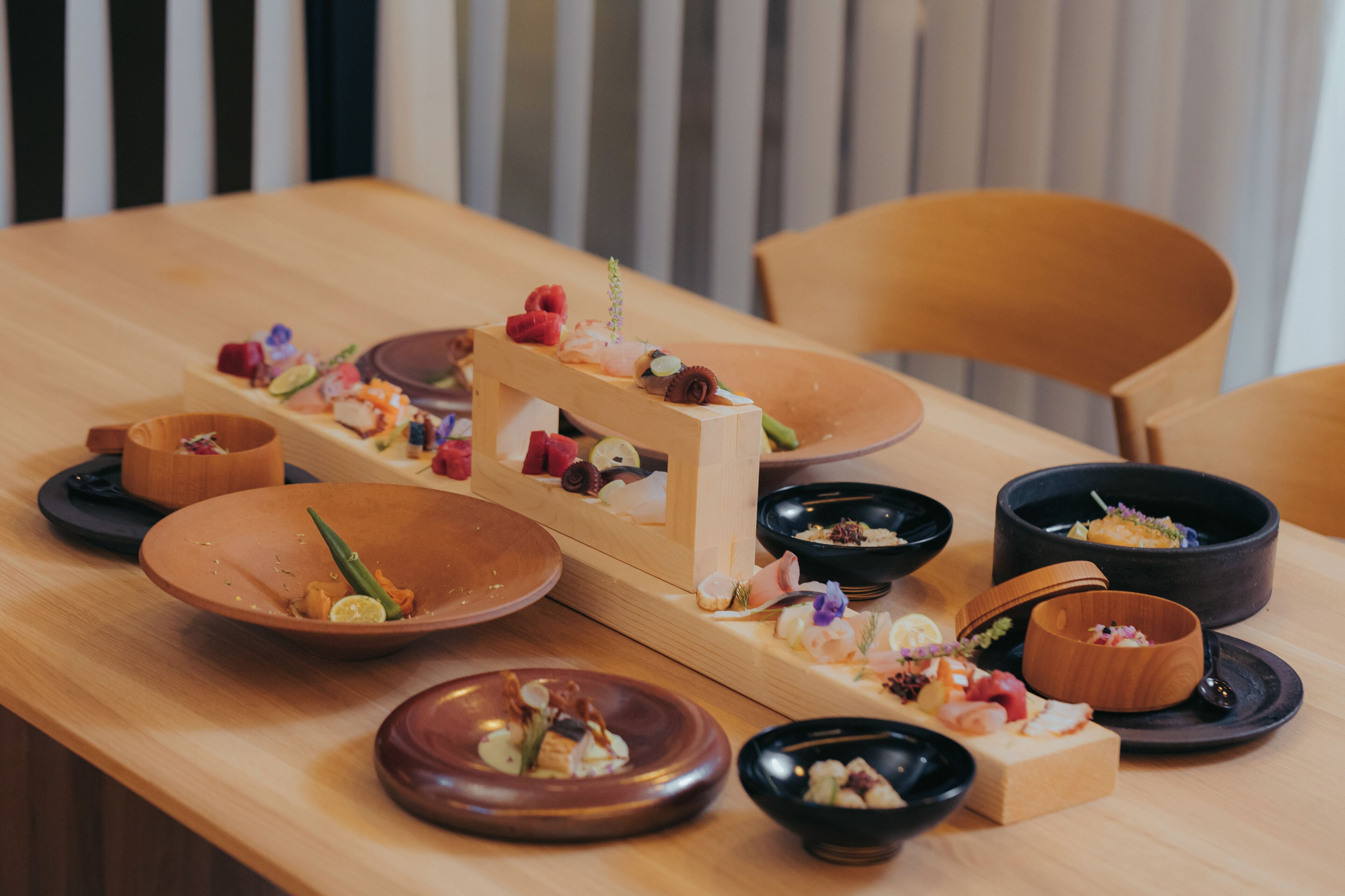 A wooden table with various dishes and bowls, likely a dining setup.