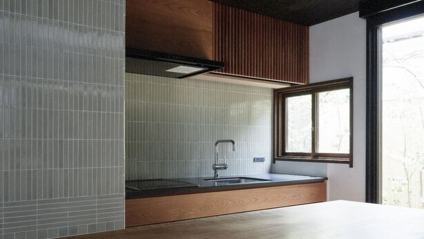 A modern kitchen with a wooden countertop, a stainless steel sink, and a window providing natural light. - Toutou Onzaki Machiya no Yado (Kurashiki)