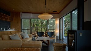 A modern living room with a sofa, chairs, a table, and a fireplace. - Seki Syu Kan (Mitoyo)