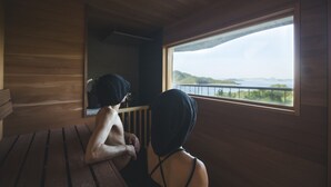 A wooden cabin with a large window offering a view of a body of water and hills. - Seki Syu Kan (Mitoyo)