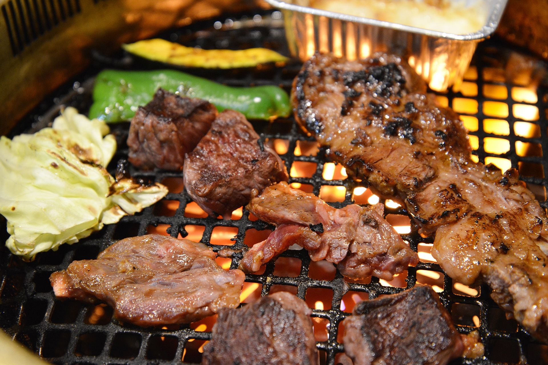 A grill with various meats and vegetables.