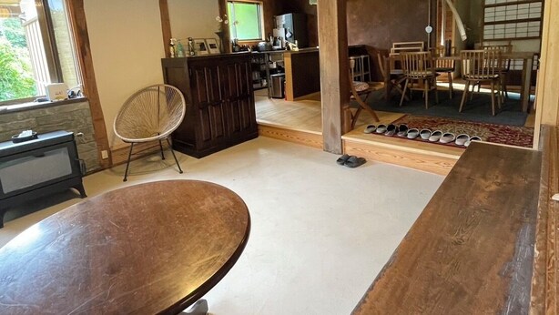 A spacious room with a wooden dining table, a bar area, and a view of the outdoors. - Sato no Yado Rishi (Isumi)