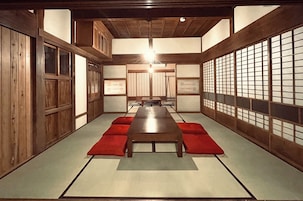 Een traditionele Japanse kamer met tatami vloerbedekking, een lage houten tafel en schuifdeuren.