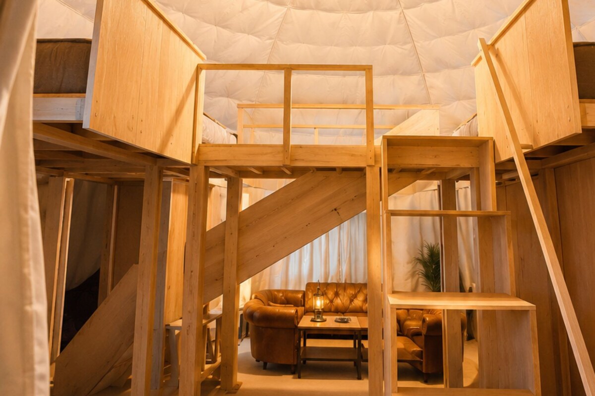 Un intérieur à plusieurs niveaux, avec une structure en bois, comprenant un canapé et une table basse situés au niveau inférieur.