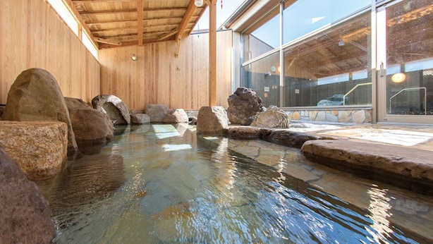 Een warmwaterbrongebied met houten wanden en grote rotsen.
