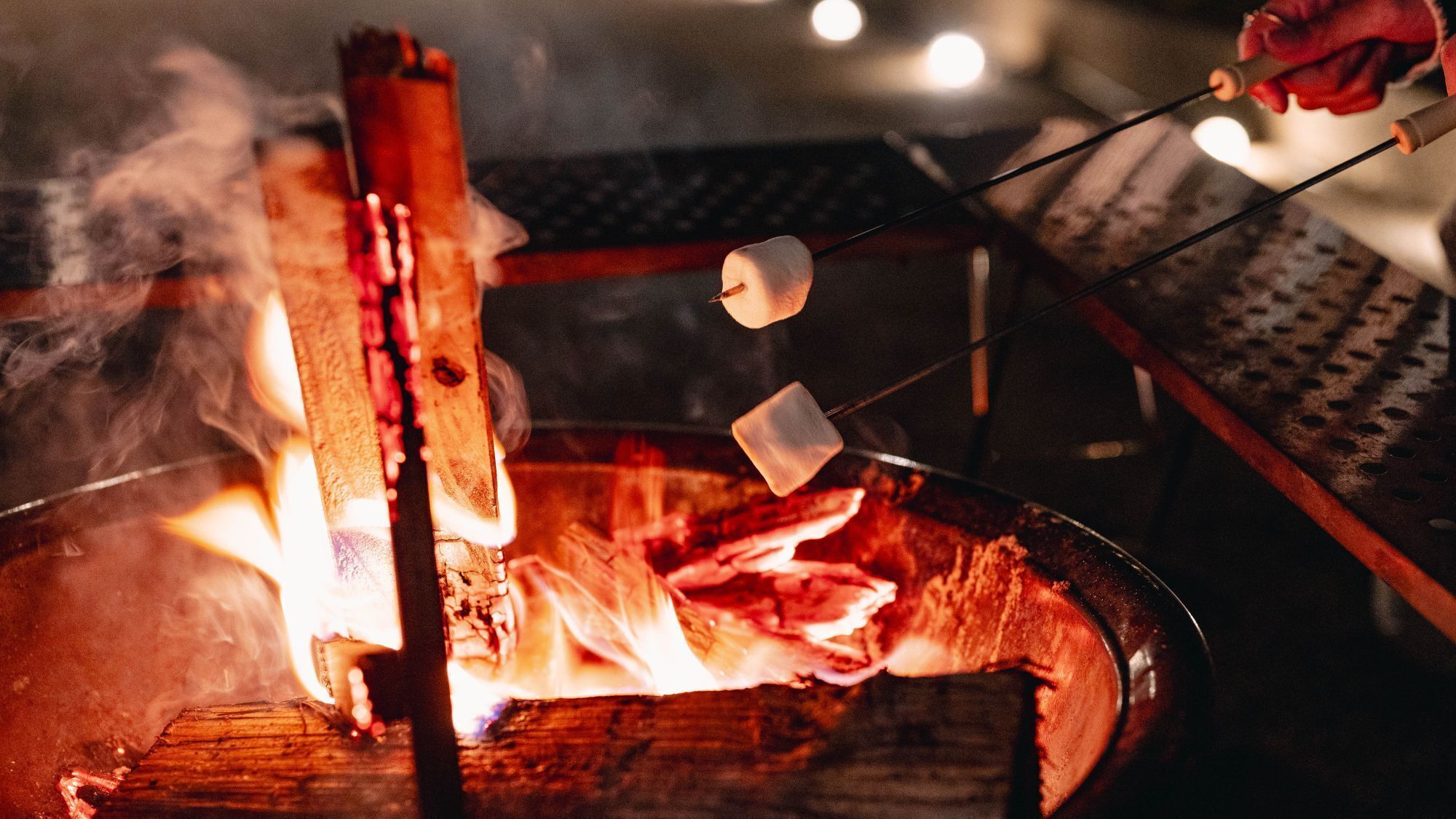 A campfire with marshmallows being roasted over it.