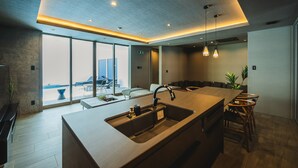Una cocina moderna con una isla grande, un lavaplatos empotrado e iluminación colgante.