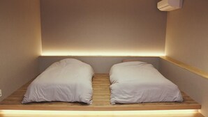 Una habitación pequeña y moderna con una cama empotrada y una plataforma de madera.