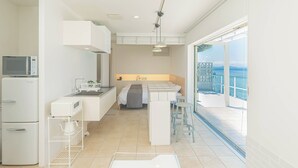 A compact kitchen with modern appliances, a dining area, and a balcony with a view. - Isola Terrace Awaji (Awaji)