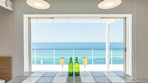 A room with a large window overlooking the sea, a tiled table with two bottles and two glasses. - Isola Terrace Awaji (Awaji)