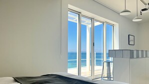 A bedroom with a large sliding glass door leading to a balcony with a view of the sea. - Isola Terrace Awaji (Awaji)