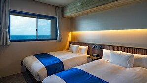 A hotel room with two beds, a window with a view of the sea, and a wooden ceiling beam. - United Resort Chatan Ocean Front (Chatan)