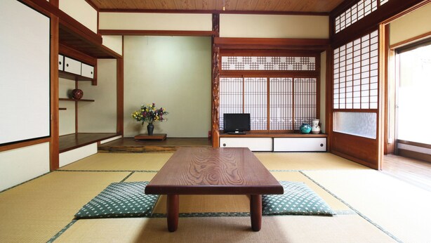 A traditional Japanese room with tatami flooring, a low wooden table, a television, and sliding doors with a grid pattern. - Katagiya (Kyotango)