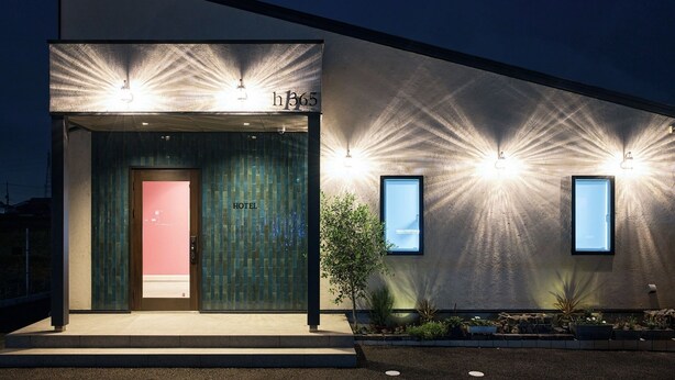 A modern hotel entrance with a glass door, a visible room number, and two illuminated windows. - Hotel H365 (Yuki)