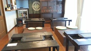 Una habitación con chimenea, televisor, un aparador de madera con cajones y una mesa con teclado.