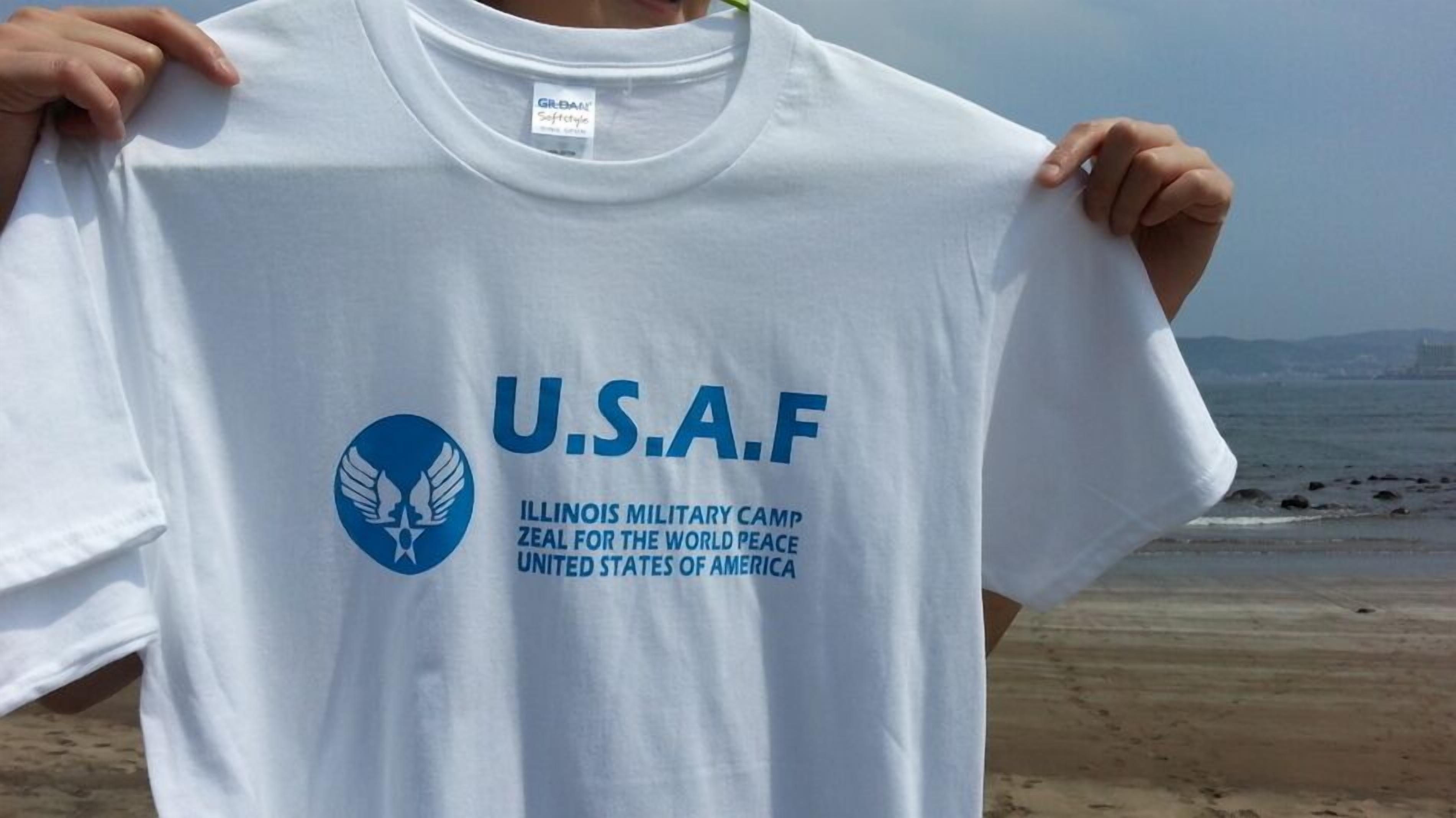 A white U.S.A.F. t-shirt with the text "Illinois Military Camp Zeal for the World Peace United States of America" and a logo.