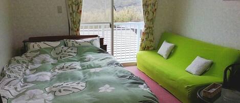 Une chambre à coucher avec un lit, un canapé vert et une petite table.