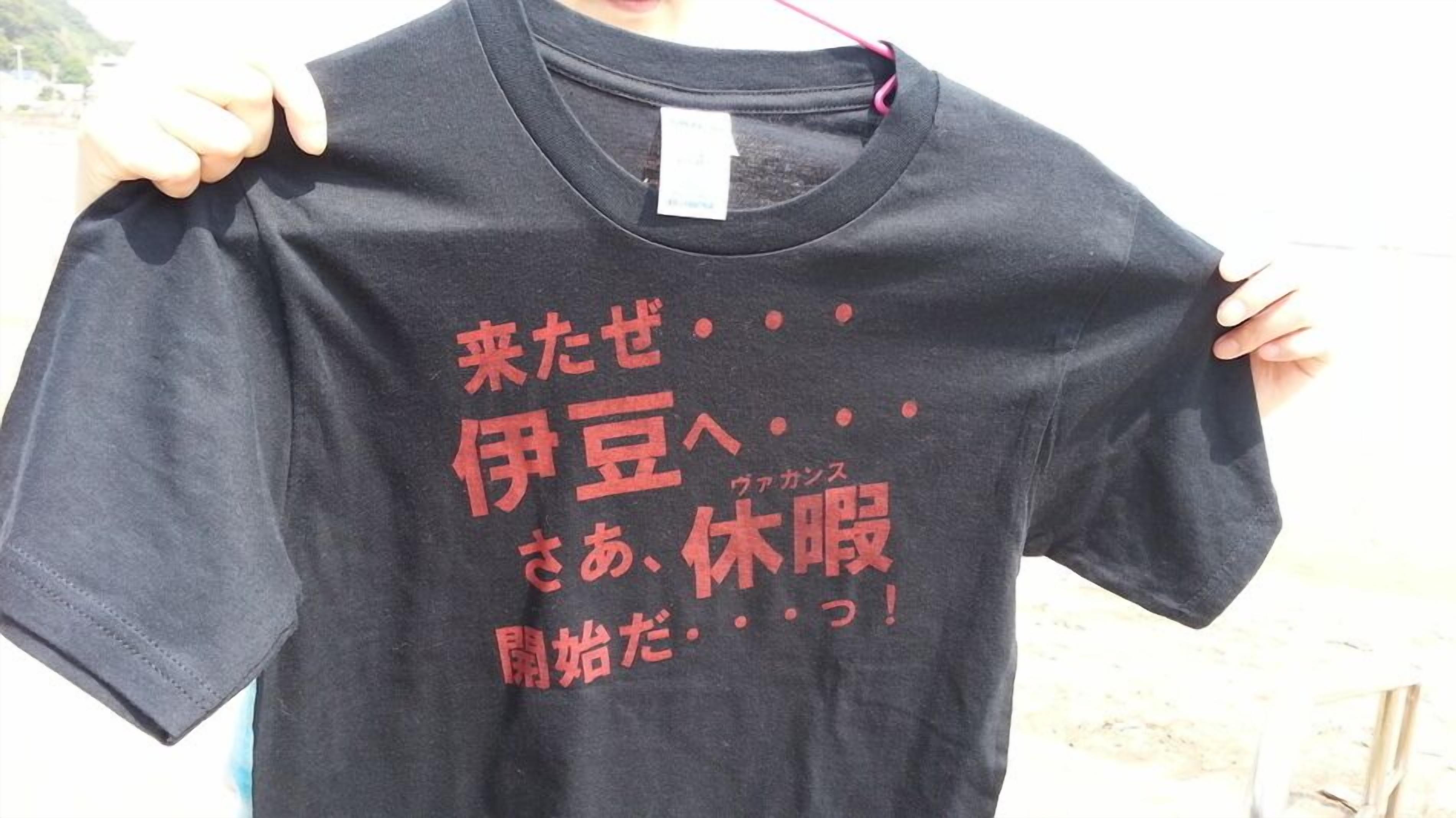 Uma t-shirt preta com texto em japonês e uma pequena etiqueta branca.