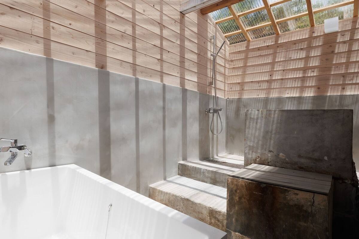 Ein modernes Badezimmer mit einer großen Badewanne, einer Duschkabine und einem Oberlicht.