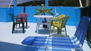 A blue and white outdoor seating area with a table and chairs. - Guesthouse Ryofu (Amami)