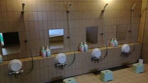 Een openbaar toilet met meerdere wasbakken, spiegels en handdrogers.