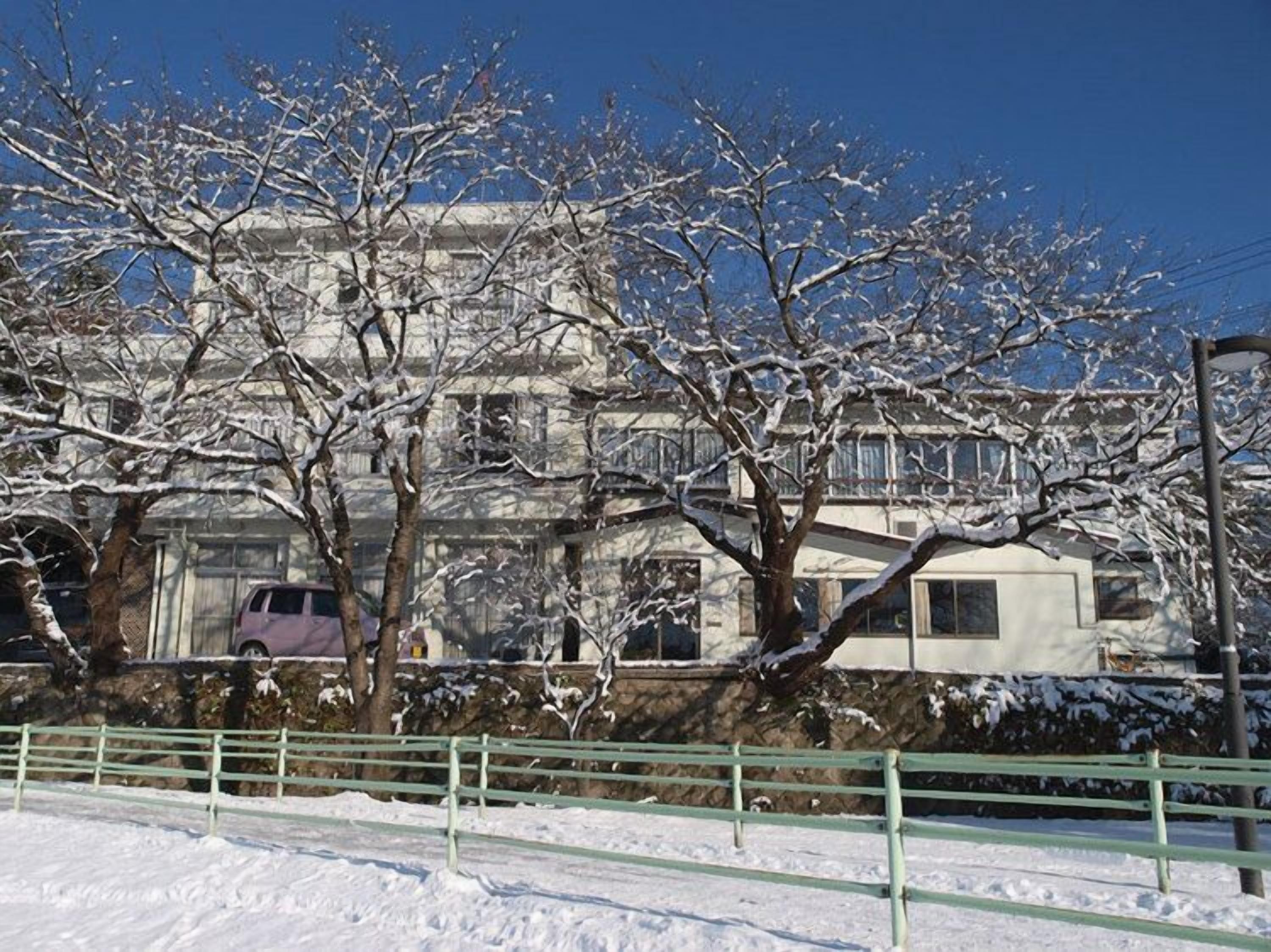 A building with multiple windows and a snow-covered landscape.