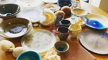 A table with various dishes and drinks, including a bowl of rice, a plate of dumplings, and several glasses of beverages.