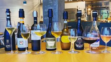 A selection of wine bottles and glasses on a wooden table in a bar setting.