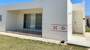 Een modern gebouw met een plat dak, grote ramen en een klein portaal.