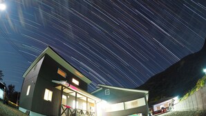 A modern house with a covered porch and a boat docked outside. - Uminchu Style Amami (Setouchi)