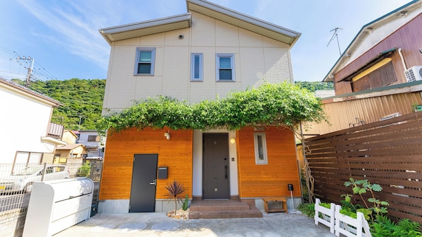 A two-story house with a wooden facade, a front door, and a small porch. - Hakoneso (Hakone)