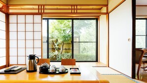 A traditional Japanese room with tatami flooring, a sliding door, and a view of greenery outside. - Yasuragiso (Amakusa)