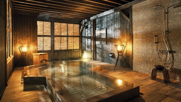 Een houten spa met een whirlpool, houten vloeren en uitzicht door grote ramen.