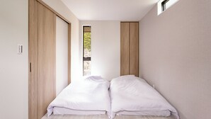 Une chambre à coucher avec un lit, une armoire en bois et une fenêtre.