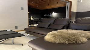 A modern living room with a sofa, a small table, and a fur throw. - Villa Cortile (Awaji)