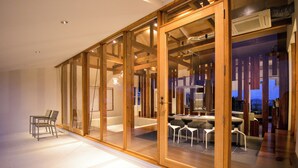 Een modern interieur met een eethoek, een bank en een glazen scheiding.